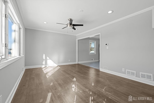 unfurnished room with visible vents, dark wood finished floors, and ornamental molding