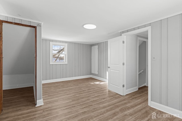 basement with light wood-type flooring and baseboards