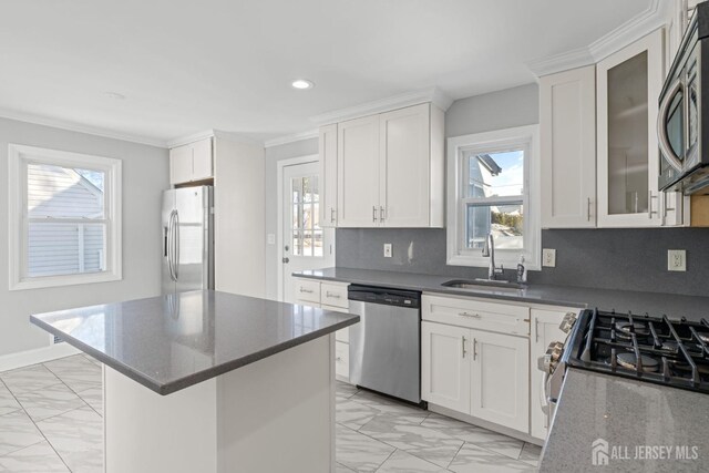 kitchen featuring a kitchen island, white cabinetry, appliances with stainless steel finishes, and sink