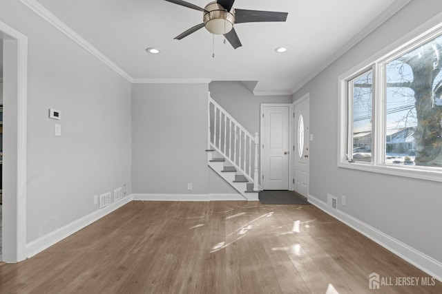 entryway featuring stairs, ornamental molding, wood finished floors, and baseboards