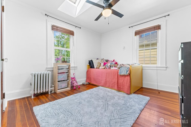 54 5th St, Fords, NJ 08863 - bedroom featuring radiator heating unit, a skylight, wood finished floors, baseboards, and ceiling fan