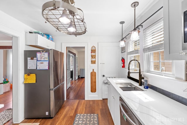 54 5th St, Fords, NJ 08863 - kitchen featuring appliances with stainless steel finishes, a sink, radiator, white cabinetry, and wood finished floors