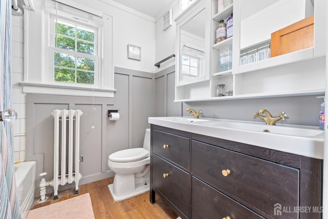54 5th St, Fords, NJ 08863 - bathroom with radiator, double vanity, wood finished floors, toilet, and ornamental molding