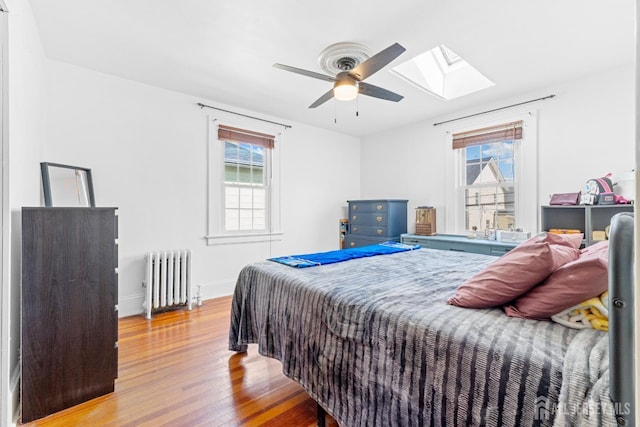 54 5th St, Fords, NJ 08863 - bedroom with radiator, a skylight, wood finished floors, baseboards, and ceiling fan