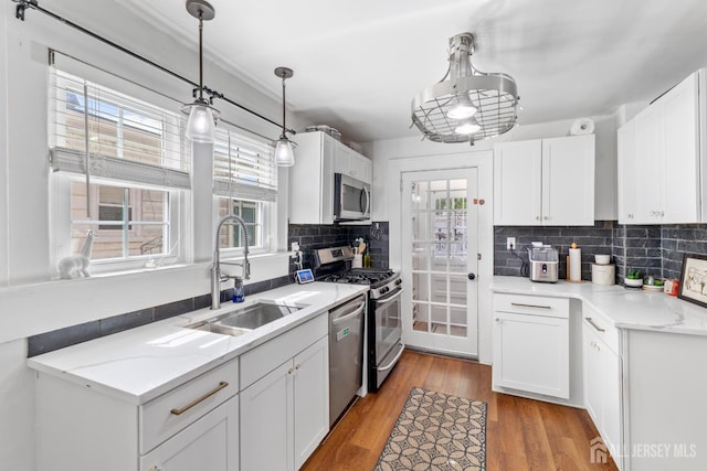 54 5th St, Fords, NJ 08863 - kitchen featuring stainless steel appliances, tasteful backsplash, white cabinets, and wood finished floors