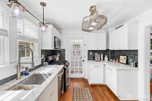 54 5th St, Fords, NJ 08863 - kitchen featuring a sink, appliances with stainless steel finishes, white cabinetry, and wood finished floors