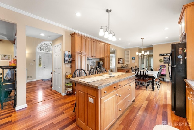 445 Grace Hill Rd, Monroe, NJ 08831 - kitchen featuring a center island, light wood-type flooring, an inviting chandelier, a kitchen bar, and freestanding refrigerator