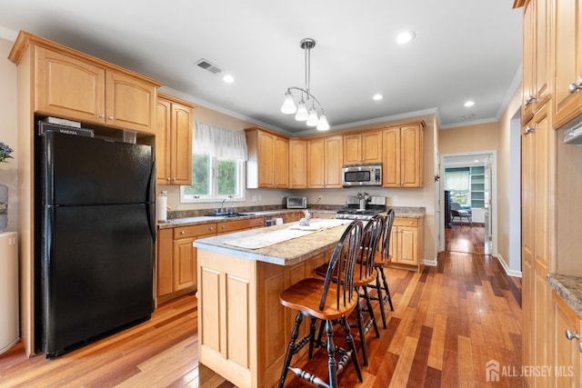 445 Grace Hill Rd, Monroe, NJ 08831 - kitchen with visible vents, a center island, ornamental molding, freestanding refrigerator, and stainless steel microwave