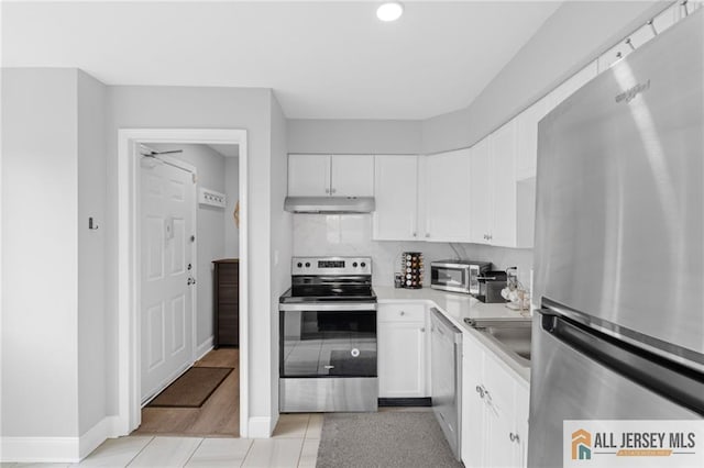 kitchen with white cabinetry, appliances with stainless steel finishes, sink, and tasteful backsplash