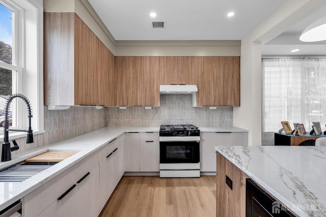 35 Glenville Rd, Edison, NJ 08817 - kitchen with gas range, exhaust hood, modern cabinets, light stone counters, and light wood-style flooring