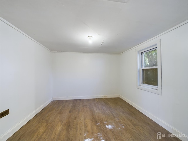 spare room with dark hardwood / wood-style floors and ornamental molding