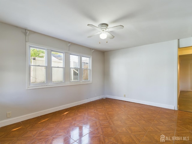 empty room featuring ceiling fan and parquet flooring