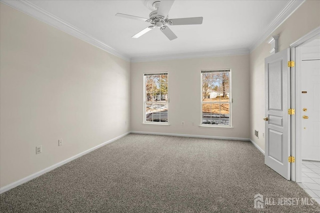 empty room with baseboards, ornamental molding, ceiling fan, and carpet flooring