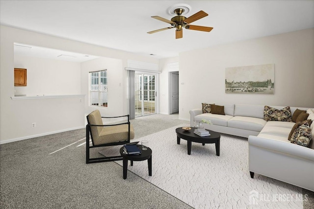 living area featuring carpet, a ceiling fan, and baseboards