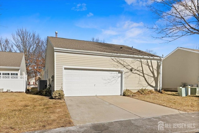 view of side of property with an attached garage, cooling unit, and concrete driveway