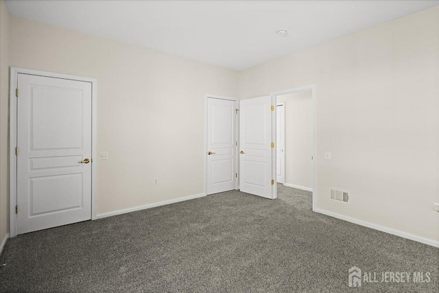 unfurnished bedroom with baseboards, visible vents, and carpet flooring