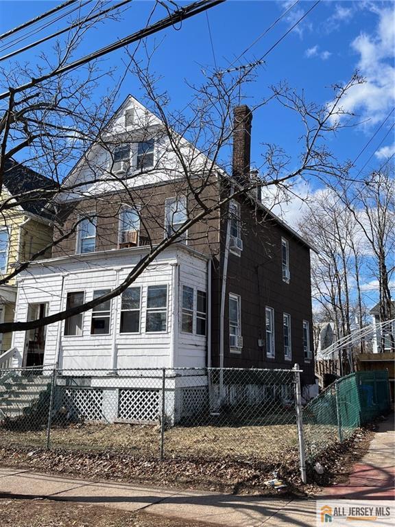 american foursquare style home with a fenced front yard and a chimney