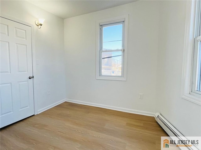 unfurnished room with light wood-style flooring, baseboards, and baseboard heating