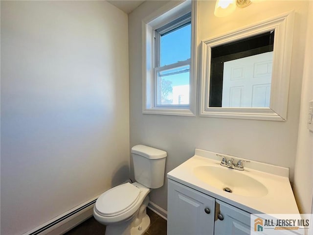 bathroom with toilet, baseboards, baseboard heating, and vanity