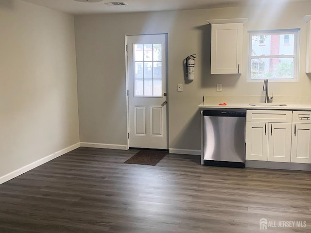 kitchen featuring dark wood-style floors, baseboards, a sink, white cabinets, and stainless steel dishwasher