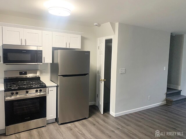 kitchen featuring white cabinets, light hardwood / wood-style floors, and appliances with stainless steel finishes