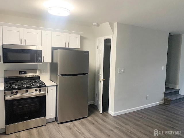 kitchen featuring stainless steel appliances, light wood-style floors, white cabinets, and light countertops