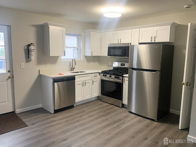 kitchen featuring white cabinets, stainless steel appliances, a wealth of natural light, and sink