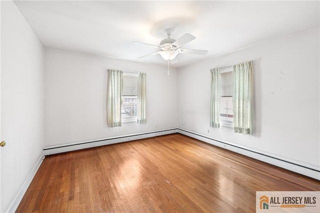 empty room featuring ceiling fan, hardwood / wood-style flooring, plenty of natural light, and a baseboard radiator