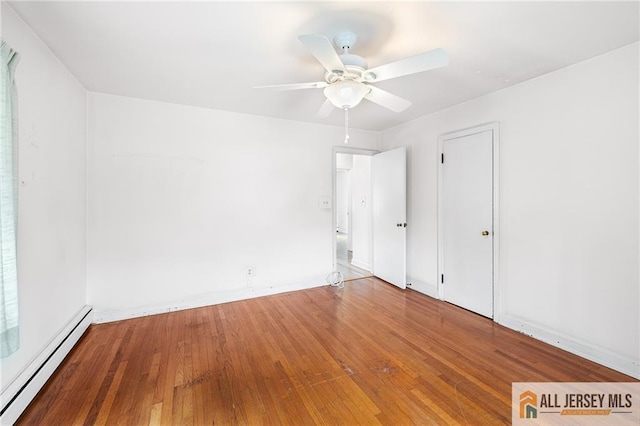 empty room with hardwood / wood-style floors, baseboard heating, and ceiling fan