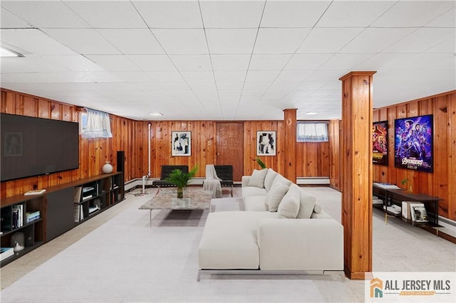 carpeted living room featuring a baseboard radiator and wooden walls