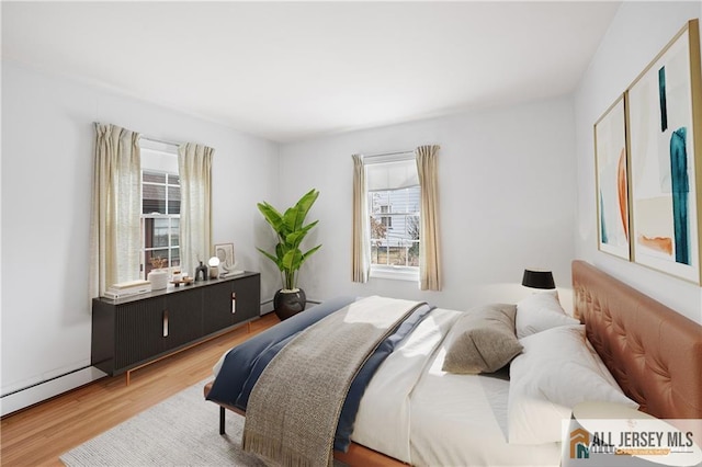 bedroom with multiple windows and hardwood / wood-style floors