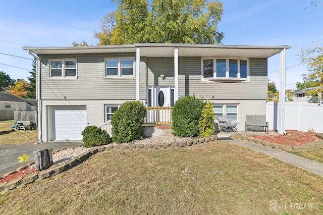 bi-level home featuring a garage and a front lawn