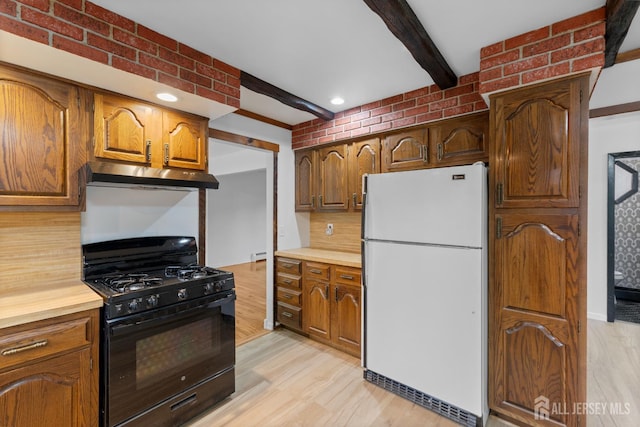 40 Montclair Ave, Edison, NJ 08820 - kitchen with freestanding refrigerator, black range with gas cooktop, under cabinet range hood, beamed ceiling, and light wood-style flooring