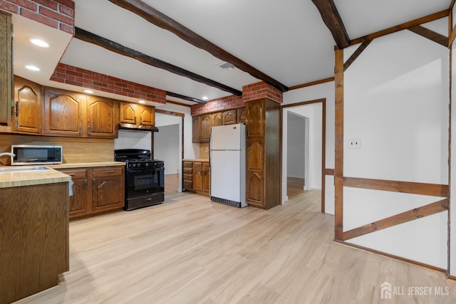 40 Montclair Ave, Edison, NJ 08820 - kitchen featuring freestanding refrigerator, black gas stove, stainless steel microwave, beam ceiling, and light countertops