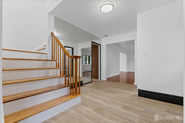 40 Montclair Ave, Edison, NJ 08820 - stairway with wood finished floors, a baseboard heating unit, and baseboards