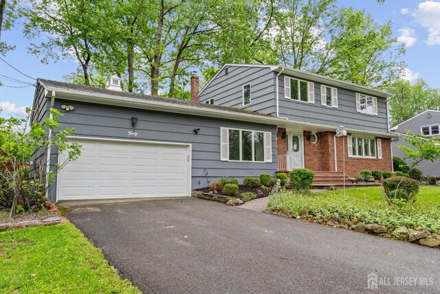40 Montclair Ave, Edison, NJ 08820 - view of front of property featuring a chimney, a garage, driveway, and brick siding