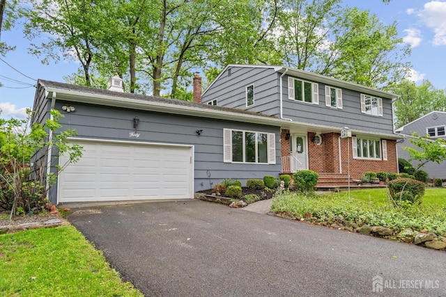 40 Montclair Ave, Edison, NJ 08820 - view of front of property with a chimney, an attached garage, driveway, and brick siding