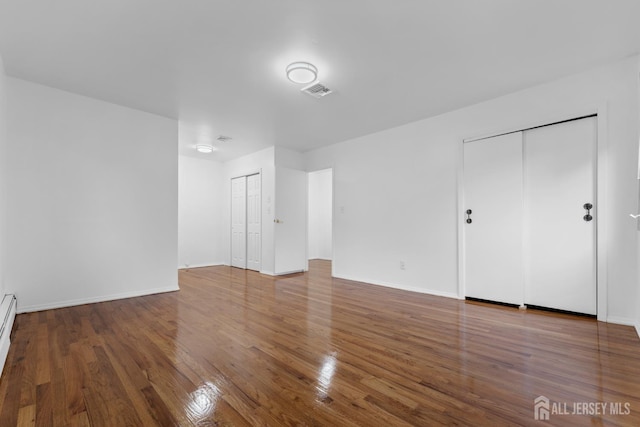 40 Montclair Ave, Edison, NJ 08820 - unfurnished living room with wood finished floors, baseboards, and a baseboard heating unit