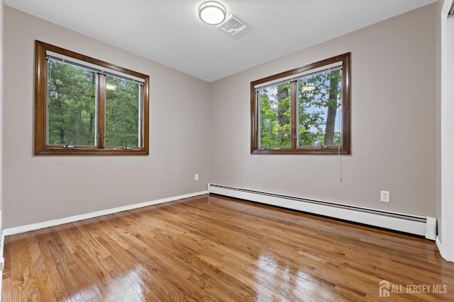 40 Montclair Ave, Edison, NJ 08820 - empty room featuring baseboard heating, plenty of natural light, wood finished floors, and baseboards