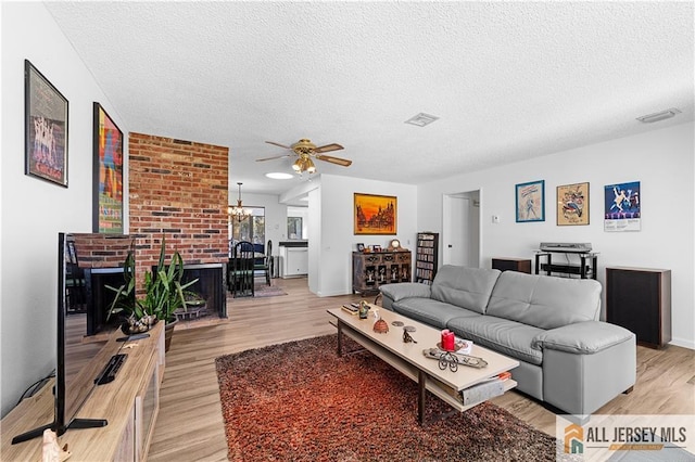 21 Celtis Plz Unit 21B, Monroe, NJ 08831 - living room with a textured ceiling, light wood-style flooring, a ceiling fan, and a brick fireplace