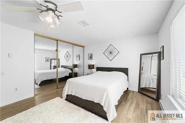 21 Celtis Plz Unit 21B, Monroe, NJ 08831 - bedroom featuring wood finished floors, a ceiling fan, a closet, a baseboard heating unit, and baseboards