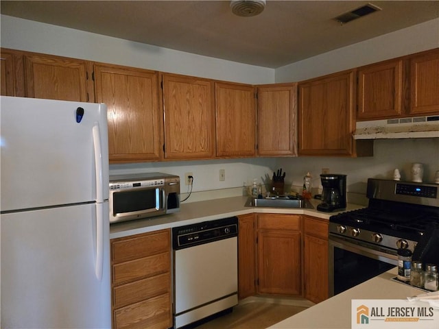 115 Griggs Pl Unit 115, East Brunswick, NJ 08816 - kitchen with appliances with stainless steel finishes, under cabinet range hood, light countertops, brown cabinets, and a sink