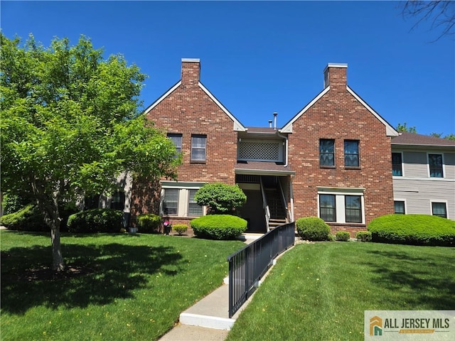 115 Griggs Pl Unit 115, East Brunswick, NJ 08816 - view of front of house with brick siding, a front yard, and a chimney