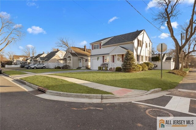 view of front of home with fence, a residential view, concrete driveway, a front yard, and a garage