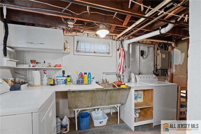 washroom featuring washer and dryer, electric panel, and cabinet space