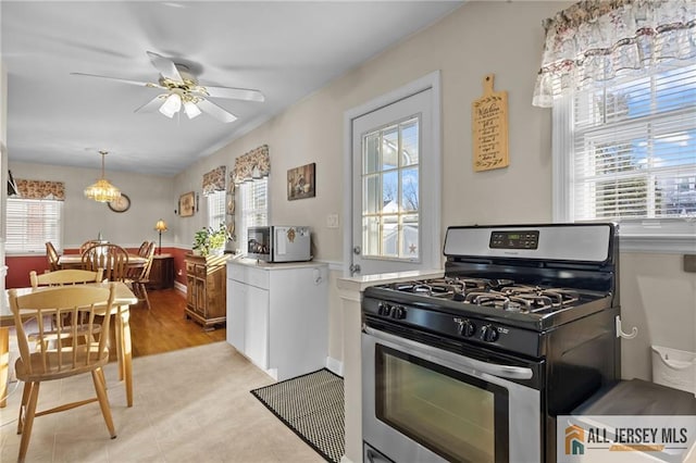 kitchen featuring appliances with stainless steel finishes, ceiling fan, hanging light fixtures, and light countertops