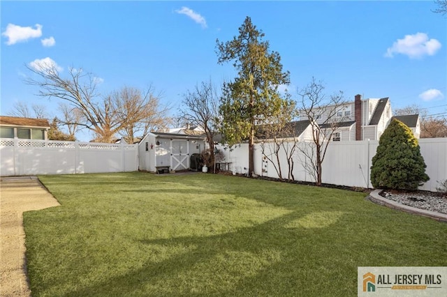 view of yard featuring an outbuilding, a fenced backyard, and a shed