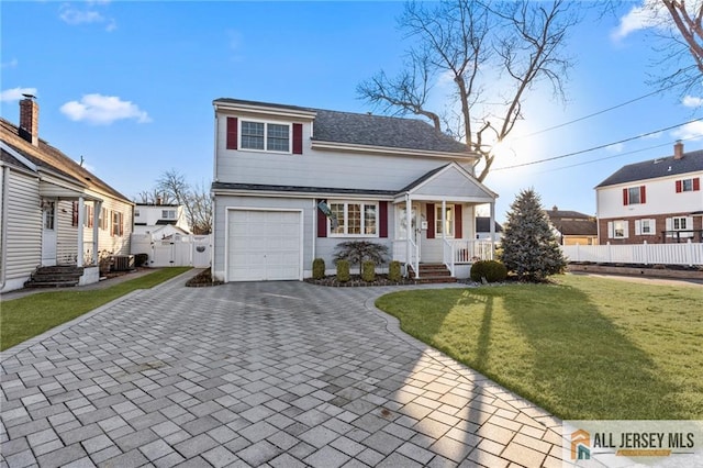 view of front of property featuring fence, a front yard, covered porch, cooling unit, and decorative driveway