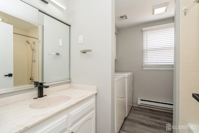 474 Revere Way Unit N, Monroe, NJ 08831 - bathroom featuring a baseboard heating unit, washer and dryer, vanity, wood finished floors, and a shower