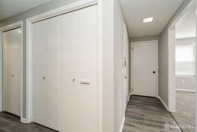 474 Revere Way Unit N, Monroe, NJ 08831 - hallway featuring a textured ceiling, baseboards, and wood finished floors